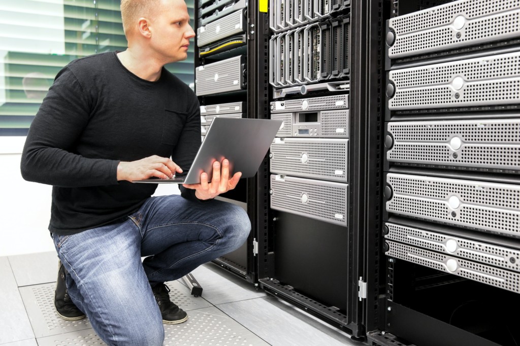 Consultant With Laptop Monitoring Servers In Datacenter
